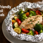 A neatly assembled, sealed heavy-duty aluminum foil packet containing raw chicken, fresh mushrooms, carrots, and thyme, ready for oven baking.