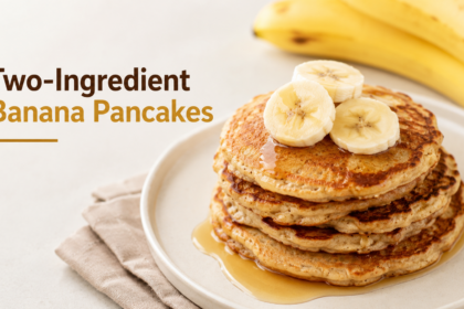 A stack of golden-brown, thin banana pancakes plated on a ceramic dish, topped with fresh strawberries and a side of Greek yogurt.