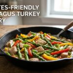 A plain dish of vibrant green asparagus and tender turkey strips tossed in a glossy lemon sauce.